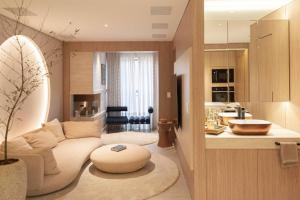 a living room with a couch and a table at Studio LUA home Batel - Luxo e Conforto no coração de Curitiba! in Curitiba