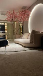 a living room with a couch and a large mirror at Studio LUA home Batel - Luxo e Conforto no coração de Curitiba! in Curitiba