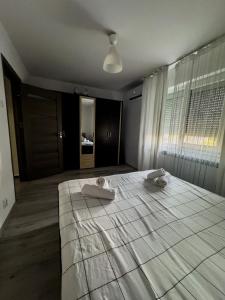 a bedroom with a large bed with two towels on it at Lion Crib in Bacău