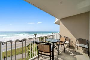 a balcony with chairs and a table and a view of the beach at Majestic Sun 0303A in Destin