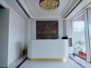 a room with a table and a chandelier at Hotel K A Square in Bhopal