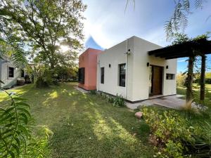a white and pink house with a yard at Comarca Andina in Ciudad Lujan de Cuyo