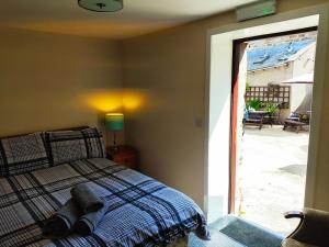 1 dormitorio con 1 cama junto a una puerta corredera de cristal en St Margaret's Hope Backpackers Hostel, en Islas Orcadas