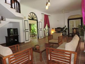 a living room with chairs and a couch and a tv at The Villa Green Inn in Negombo