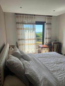 una camera da letto con un letto grande e una finestra di Mar Da Luz Apartment a Luz Altre 27 foto