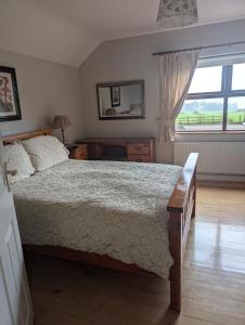 Un dormitorio con una cama grande y una ventana. en Clare House Bed & Breakfast, en Ballycastle