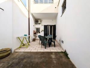 patio ze stołem i krzesłami w budynku w obiekcie Oikia Vacanze Diso Giulia w mieście Diso