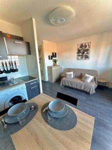 una cucina e un soggiorno con un tavolo e un letto di Studio cosy à deux pas de la mer 2LAMP36 a Le Barcarès