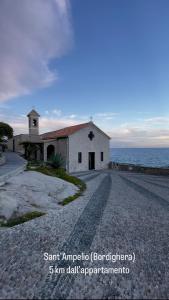 a church on a gravel road next to the ocean at Casa di Bea in Ventimiglia