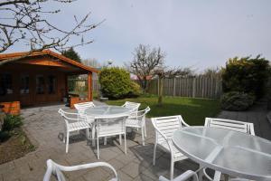 a group of white tables and chairs on a patio at Bed & Breakfast d'Ouwe Smidse in Kamperland