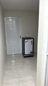 a room with a white door and a refrigerator at Edifício Ribeiro in Patos