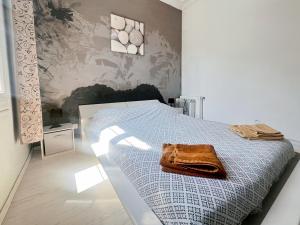 Un dormitorio con una cama con una toalla encima. en Proche promenade des anglais et de la mer, en Niza