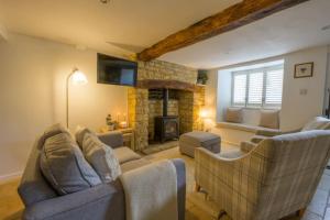 ein Wohnzimmer mit Couch und Kamin in der Unterkunft Bourton-on-the-Water Lovely 2Bed Cotswold Cottage in Bourton on the Water