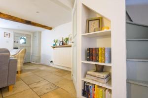 ein Zimmer mit einem Bücherregal voller Bücher in der Unterkunft Bourton-on-the-Water Lovely 2Bed Cotswold Cottage in Bourton on the Water + 7 Fotos