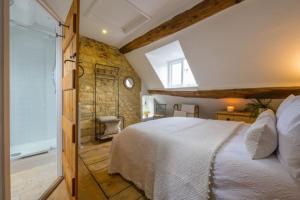 ein Schlafzimmer mit einem weißen Bett und einem Fenster in der Unterkunft Bourton-on-the-Water Lovely 2Bed Cotswold Cottage in Bourton on the Water