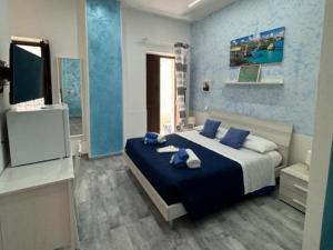a bedroom with a large bed and a television at Pomillo Rooms in Noto