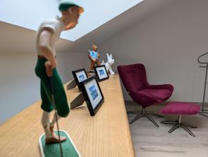 a toy man standing on a surfboard in a room at Taylor - 2 pers - Appartement Dinan in Dinan +25 photos