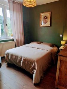 a bedroom with a bed in a green wall at Les jardins de Romy in Calais