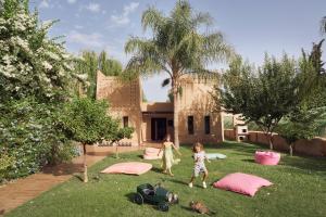 two children playing in the yard of a house at Mandarin Oriental, Marrakech in Marrakesh