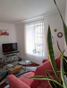 a living room with a red couch and a large window at Taylor - 2 pers - Appartement Dinan in Dinan