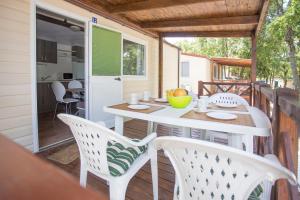 weranda ze stołem i krzesłami na tarasie w obiekcie CHERRY Premium BIANCA Mobile homes Zelena Laguna w Poreču
