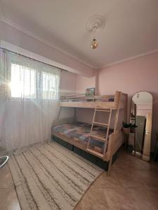 a bedroom with a bunk bed and a window at Villa Mihaila in Ofrínion
