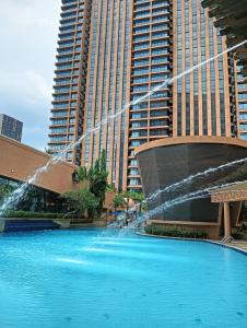 a swimming pool with a fountain in front of a building at 100 Service suites At Times Square KL in Kuala Lumpur