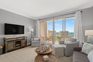 a living room with a television and a couch and chairs at Ariel Dunes II 1106 in Destin