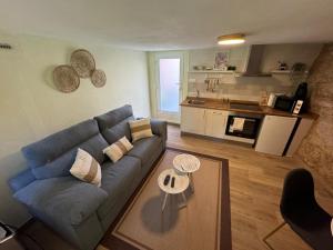 a living room with a blue couch and a kitchen at Casadeira de Mucha in Camariñas