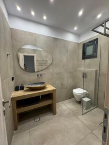 a bathroom with a sink and a toilet and a mirror at Deos luxury house in Ios Chora +11 photos