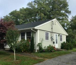 a small white house with at The Buoys in Gloucester