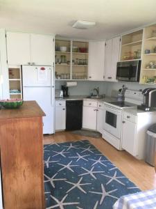 a kitchen with white appliances and a blue rug at The Buoys in Gloucester +11 photos
