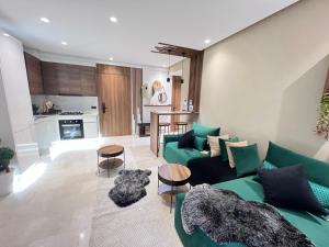 Studio4 Comfortable rest في الدار البيضاء: غرفة معيشة مع أريكة خضراء ومطبخ