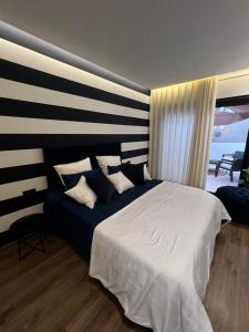 Studio4 Comfortable rest في الدار البيضاء: غرفة نوم بسرير كبير وجدار مخطط