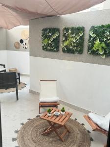 Studio4 Comfortable rest في الدار البيضاء: غرفة معيشة مع طاولة وكرسي +صورتان
