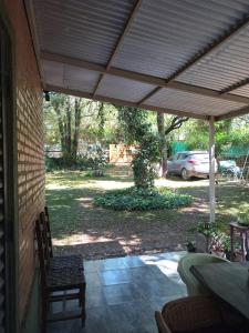 a patio with a table and chairs under a roof at Casa en Villa Los Aromos cerca del río in Villa Los Aromos
