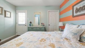 a bedroom with a bed with an orange and white stripes at Beach access close to Walmart, Bowling,skating and Game room in Panama City Beach +81 photos