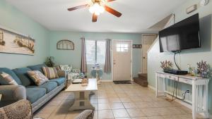 a living room with a blue couch and a flat screen tv at Beach access close to Walmart, Bowling,skating and Game room in Panama City Beach