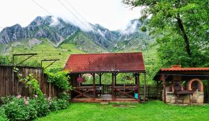 a gazebo in a yard with mountains in the background at Panoráma Panzió Torockó in Rimetea +11 photos
