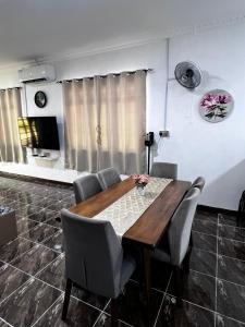 a dining room with a wooden table and chairs at K-Villa Homestay Tuaran in Kampong Marabahai