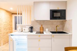 a white kitchen with a sink and a microwave at Duplex calme à Caen - proche Zénith & commerces in Caen