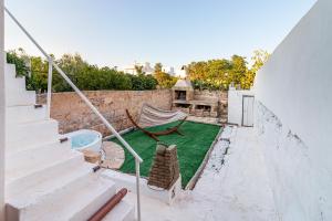 a patio with a hammock and a swimming pool at Iremìa B&B in Racale