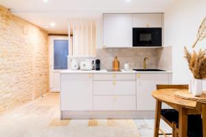 a kitchen with white cabinets and a table at Duplex calme à Caen - proche Zénith & commerces in Caen +13 photos