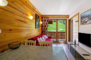 a living room with a red couch and a television at A3 405 Appart au pied des pistes in Saint-François-Longchamp +11 photos