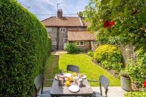 einen Tisch mit Essen darauf im Garten in der Unterkunft Willow Cottage South Creake 2 in South Creake