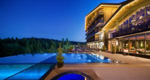 a hotel with a swimming pool in front of a building at Apartel Skhidnytsya in Skhidnitsa