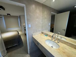 a bathroom with a sink and a bed and a mirror at Hotel America in San Juan