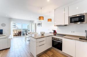 a kitchen with white cabinets and a counter top at BENALBEACH Apartamento Exclusivo in Benalmádena