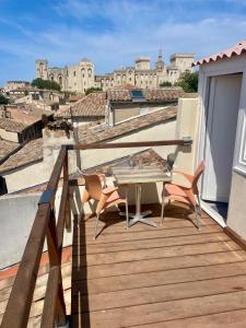 a wooden deck with a table and chairs on a balcony at Le Toit D'Avignon - Intra-muros - Terrasse vue Palais des Papes - Idéal Festival - Climatisation - WiFi in Avignon