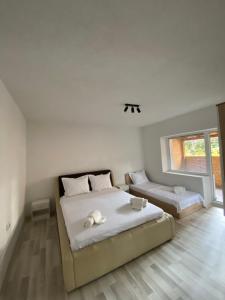 a white bedroom with two beds and a window at Lake City Apartment in Struga